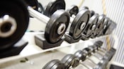 Staggered rows of neatly organized barbells of differing weights in an exercise room
