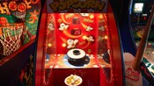 Un jeu d’arcade de maïs soufflé, flanqué de jeux d’arcade de basketball et de baseball