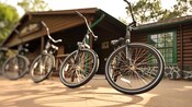 4 bicicletas enfileiradas em frente a um ponto de aluguel