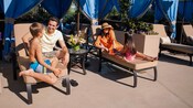 Une famille de 4 personnes profite d’une cabana au bord de la piscine