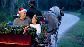 A dad and daughter enjoy an enchanting moment on a holiday sleigh ride guided a Disney Cast Member