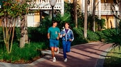 Un hombre y una mujer corren por un camino en un resort de Disney