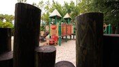 Uma vista rodeada por toras de madeira de um playground infantil