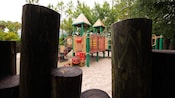 Uma vista rodeada por toras de madeira de um playground infantil