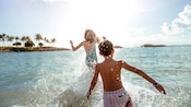 A girl and a boy splashing in the shallow ocean