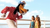Sailor Goofy entertaining 2 girls on a Disney Cruise Line ship deck