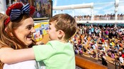 A mother happily embracing her son during a Sailing Away Deck Party on a Disney Cruise Line ship