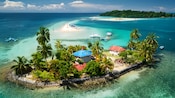 A tropical island in Panama with palm trees and small houses surrounded by clear water and a sandbar