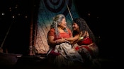 Moana sitting on her canoe with Gramma Tala during Disney The Tale of Moana, a stage show on board the Disney Treasure