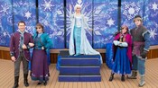 Elsa e Anna com outros cast members de Frozen posando no deck de um navio de cruzeiro da Disney