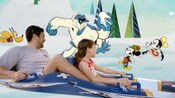 An artist rendering of 2 Guests riding the Aqua Mouse water ride past a screen showing Mickey Mouse, Minnie Mouse and Pluto encountering an abominable snowman