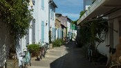 Bicycles leaning against vintage buildings in a narrow alleyway