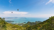 Cable cars traveling above lush mountains with panoramic views of islands and clear waters in Langkawi