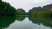 A mangrove waterway flanked by limestone karst mountains in Langkawi, Malaysia