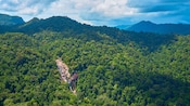 Lush rainforest and rolling mountains surrounding a waterfall in Langkawi, Malaysia