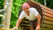 A Guest climbing through a wooden tunnel during a challenge course