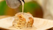 A Bajan bake with gravy being poured on it