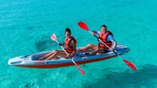 Un hombre y una mujer remando en un kayak en Kuzá Beach and Adventure Park en Cozumel, México