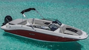 A small speed boat anchored in shallow water