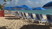 Two rows of loungers and umbrellas on a beach at George Town, Grand Cayman