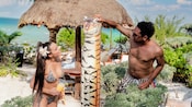 A man and a woman interacting with a tiger sculpture during the Mi Casa Es Su Casa private beach getaway in Progreso, Mexico