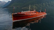 A Guest on a wooden touring boat opening a bottle of wine over the water