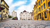A cobblestone town square surrounded by historic buildings in Ålesund, Norway