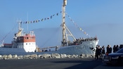 Guests gathered on the bow of the MS Polarstar as it cruises into port