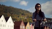 Um hóspede guiando um Segway, com a arquitetura hanseática ao fundo