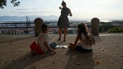 Children participating in an interactive activity at a scenic overlook in Cagliari, Italy