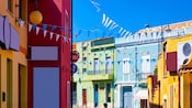 A narrow street adorned with decorative flags and lined with traditional Mediterranean buildings