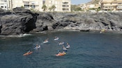 Visitantes paseando en kayak por una sección rocosa de la costa en Cartagena, España