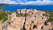 A coastal town near the Port of Civitavecchia with a grand castle at the top of the hill overlooking the water