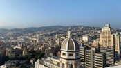View of Genoa featuring a cityscape with densely packed buildings and a prominent dome in the foreground