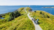 Four cyclists resting on a coastal path near Haugesund with views to the ocean