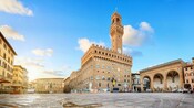The Piazza della Signoria in Florence with a large stone tower and clock