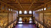 Un salón ornamentado en el Palazzo Vecchio con paredes pintadas al fresco y un techo decorativo