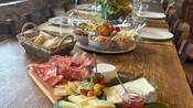 A table set with a traditional Italian charcuterie board, fruits, jams, bread and antipasti bowls