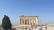 A large group of tourists in front of the Parthenon in Greece