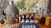 Mesa de madera con vasos, botellas, vino, jarras de jugo y un plato de pasteles