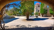 An archway framing a courtyard and domed tower at the Monastery of the Virgin Mary