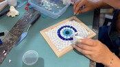 Un Visitante trabajando en un plato de mosaico en un taller en Rodas, Grecia