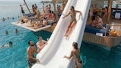 Um hóspede descendo no escorregador do Blu Ocean Club Cozumel, um clube aquático flutuante em Cozumel