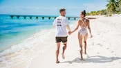 A couple walking hand in hand on a beach