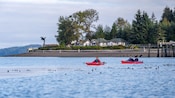 Three Guests paddling on kayaks near the Hoonah waterfront in Icy Strait, Alaska