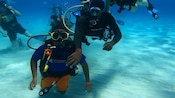 A group of scuba divers posing for a picture in shallow water