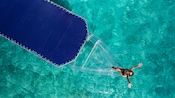 A woman relaxing at the bow of a clear boat with a canvas top at sea