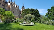 The lush grounds of Schwerin Castle with a small garden surrounded by trees and flowers