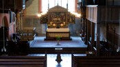An alter and pews inside an empty monastery