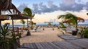 A beach with palm trees, plants, chairs and wooden decks in Saint John’s, Antigua